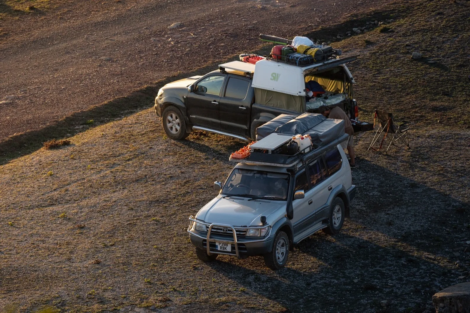 Unsere beiden Expeditionsfahrzeuge, an einem Hang geparkt, zur goldenen Stunde