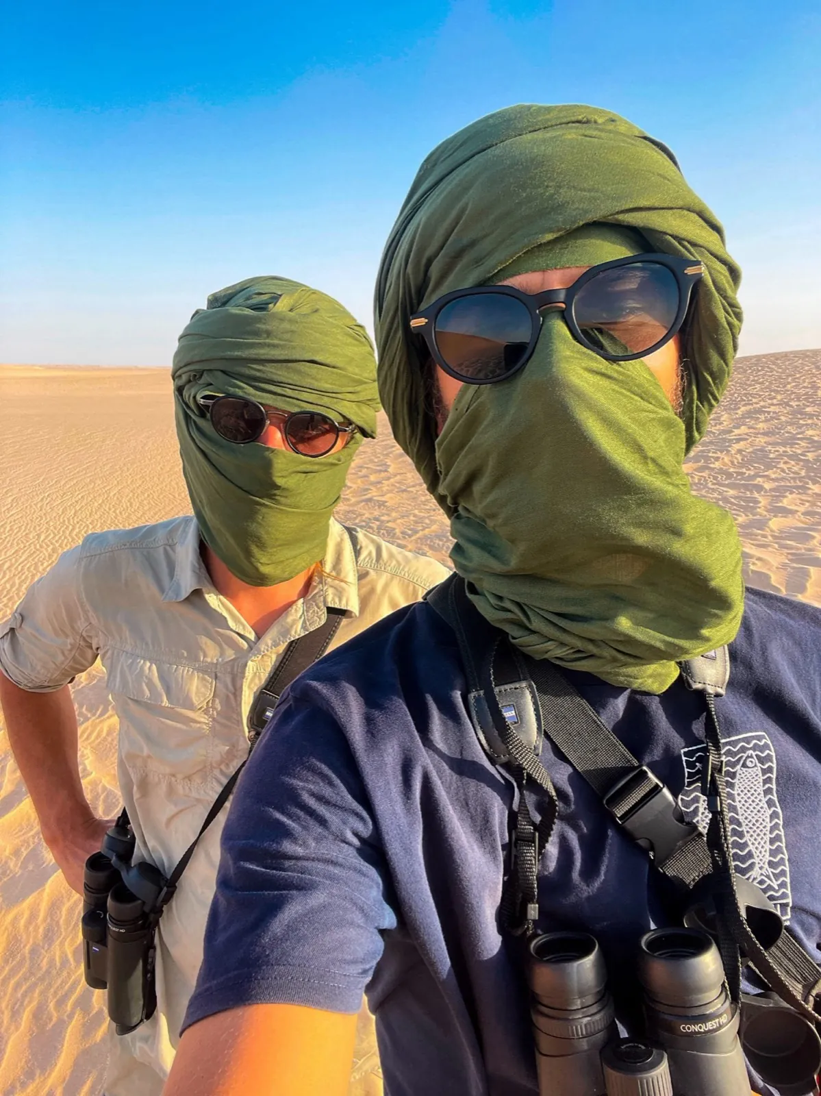 Axel und Ario mit Wüstentüchern und Sonnenbrillen im Sand
